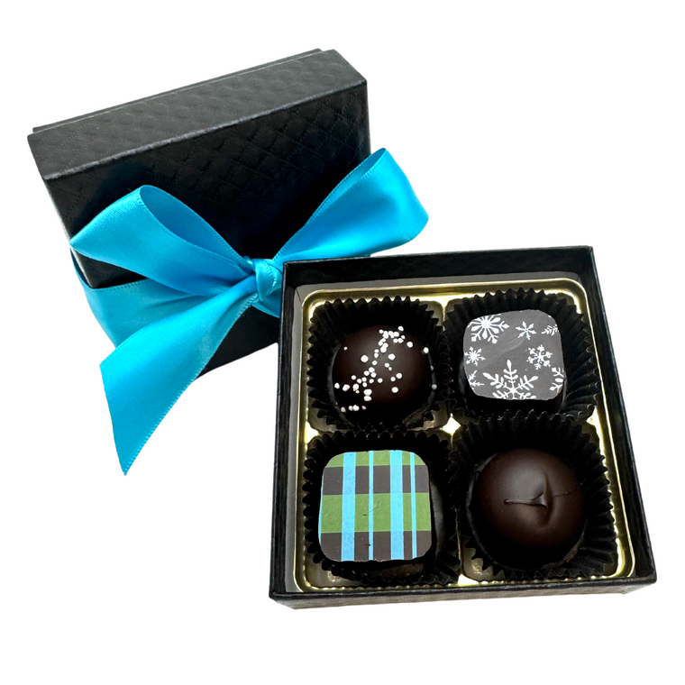 4-piece artisan Winter Collection chocolate box from Chocolat Celeste, featuring snowflake and plaid bonbons in a black quilted box with turquoise satin ribbon – part of Christmas in July Pre-Sale